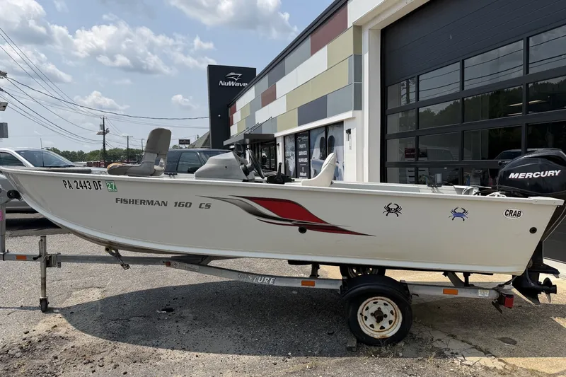 The Image of 2010 Alumacraft Fisherman 160 CS boat on trailer, parked outside a building. - 0
