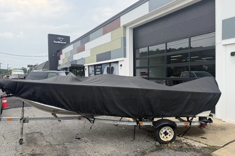 Slide: The Image of 2010 Alumacraft Fisherman 160 CS boat covered, parked outside NuWave building. - 12