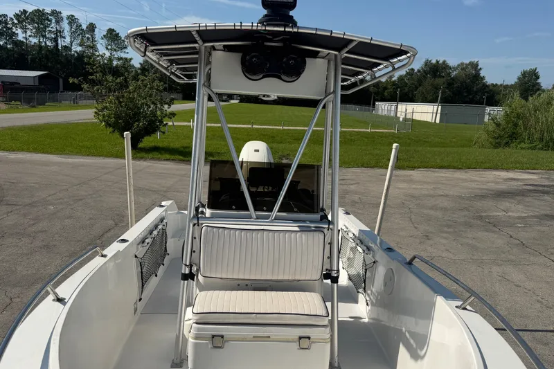 Slide: The Image of 1999 Robalo 2120 Center Console boat with T-top, parked on concrete, surrounded by greenery. - 16
