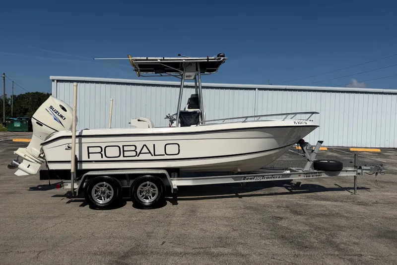 The Image of 1999 Robalo 2120 Center Console boat on trailer, featuring Suzuki outboard motor. - 1