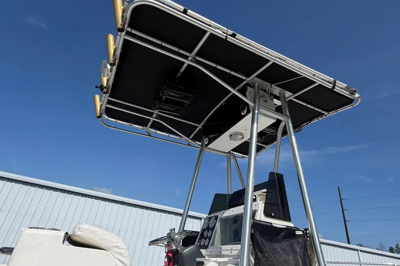 Slide: The Image of 1999 Robalo 2120 Center Console boat with T-top under clear blue sky. - 24