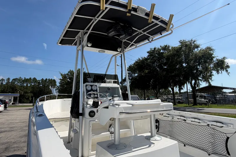 Slide: The Image of 1999 Robalo 2120 Center Console boat with T-top, parked outdoors under clear sky. - 26