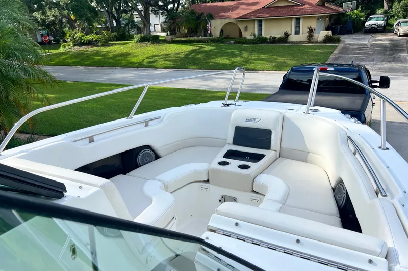 Slide: The Image of 2015 Boston Whaler 270 Vantage boat with spacious seating, parked in a residential driveway. - 66