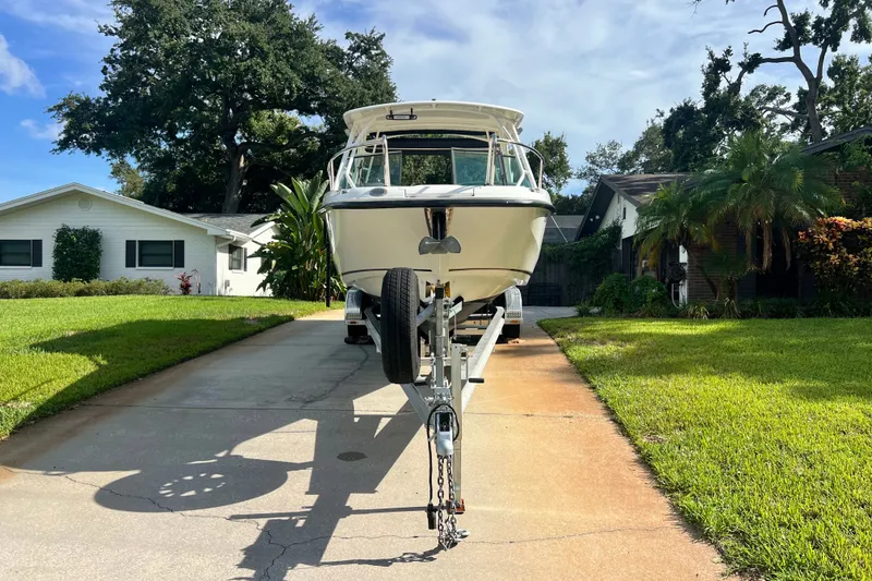 The Image of 2015 Boston Whaler 270 Vantage boat on trailer in residential driveway. - 1