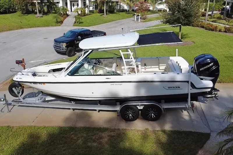 Slide: The Image of 2015 Boston Whaler 270 Vantage boat on trailer, parked in driveway. - 30
