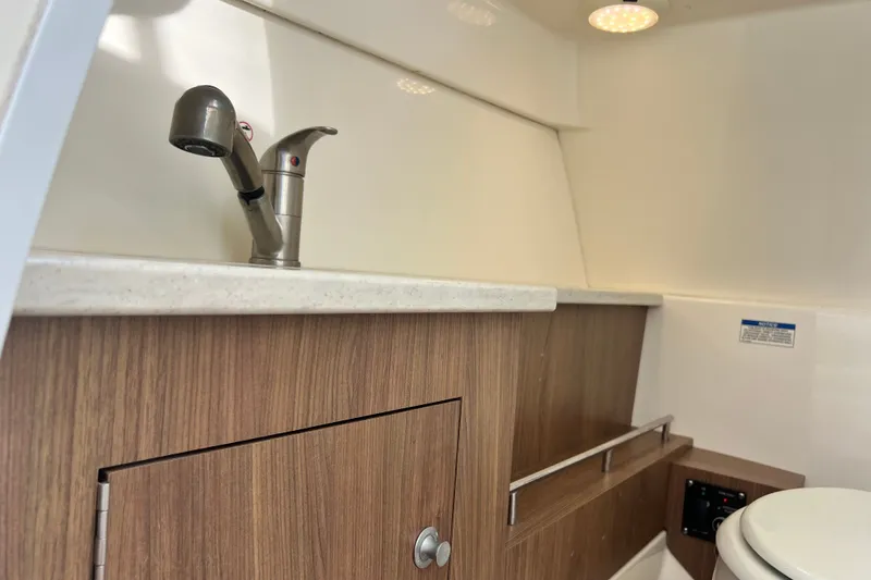 Slide: The Image of Interior of a 2015 Boston Whaler 270 Vantage boat, featuring a compact sink and storage. - 90