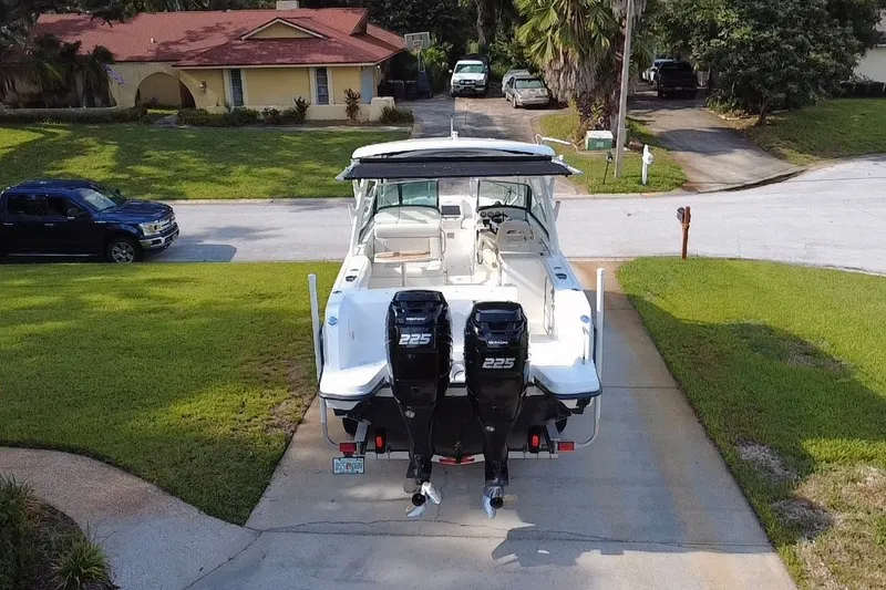 Slide: The Image of 2015 Boston Whaler 270 Vantage boat with twin 225 engines parked in driveway. - 26
