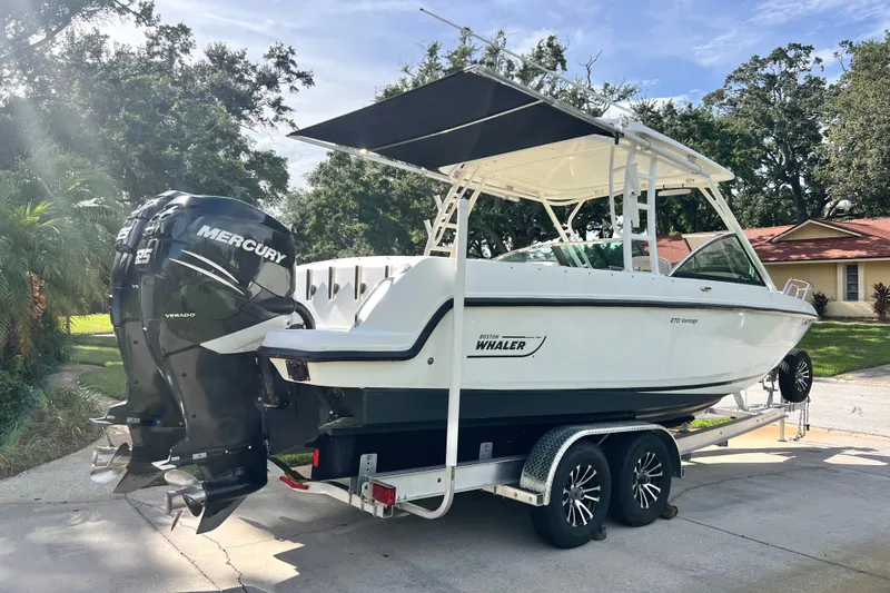 Slide: The Image of 2015 Boston Whaler 270 Vantage boat on trailer with Mercury engines, parked outdoors. - 4