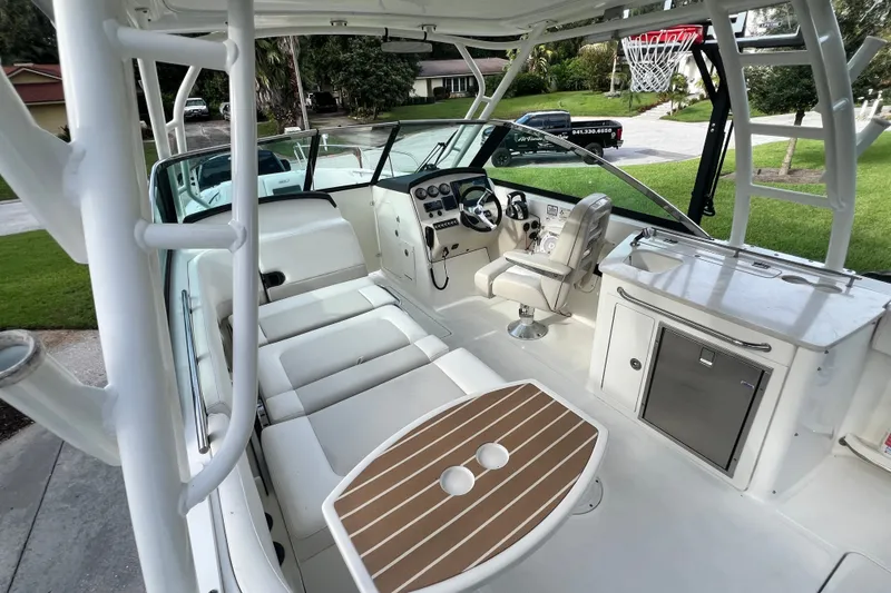 Slide: The Image of 2015 Boston Whaler 270 Vantage boat interior with seating, helm, and kitchenette. - 97