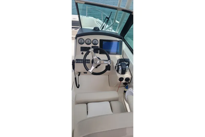 Slide: The Image of 2015 Boston Whaler 270 Vantage helm with steering wheel and navigation controls. - 7