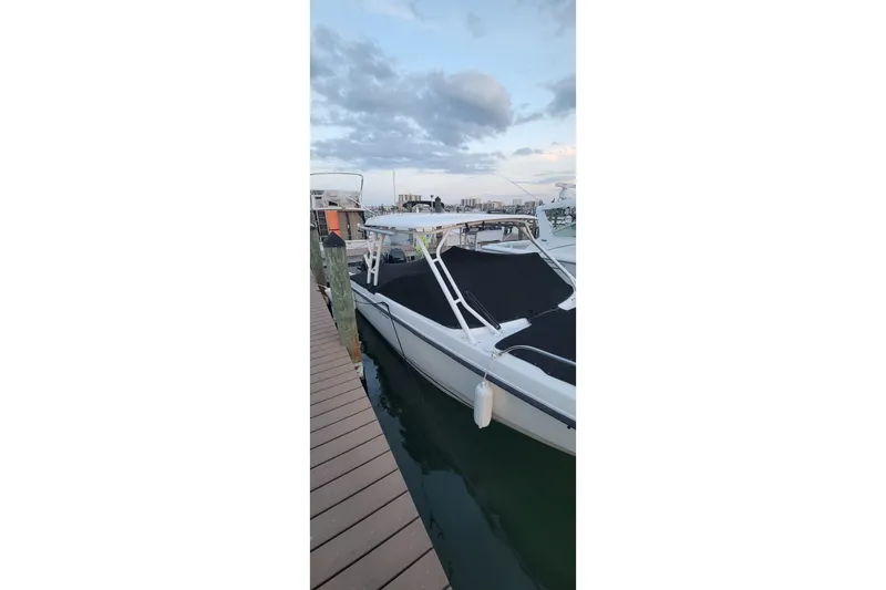 Slide: The Image of 2015 Boston Whaler 270 Vantage docked at marina under cloudy sky. - 3