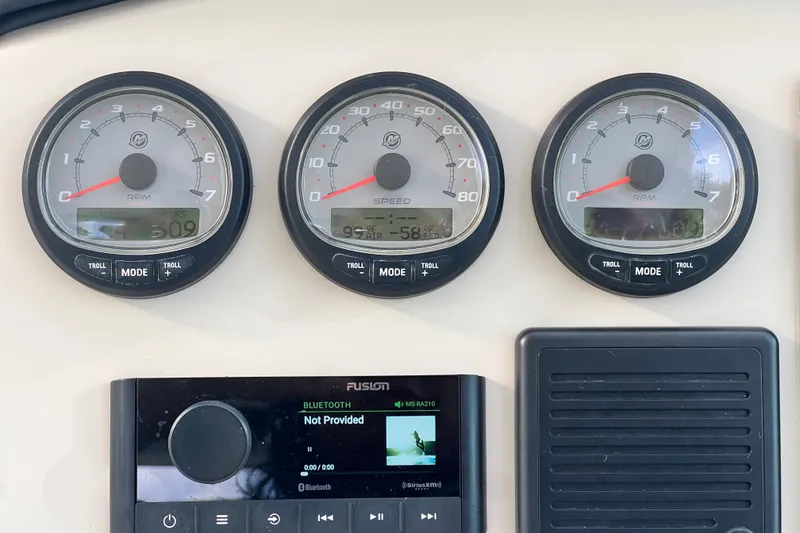 Slide: The Image of Dashboard of a 2015 Boston Whaler 270 Vantage with gauges and a Fusion audio system. - 80