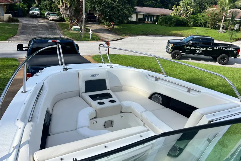Slide: The Image of 2015 Boston Whaler 270 Vantage boat with spacious seating, parked in a residential driveway. - 75