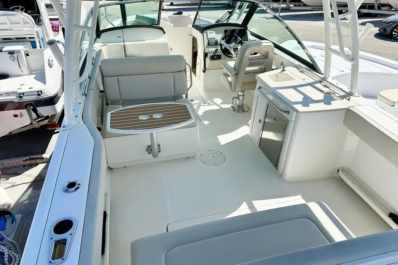 Slide: The Image of 2015 Boston Whaler 270 Vantage boat interior with seating, helm, and kitchenette. - 4