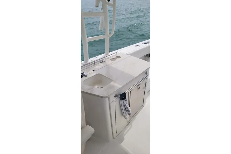 Slide: The Image of 2015 Boston Whaler 270 Vantage boat interior with sink and storage, ocean view. - 2