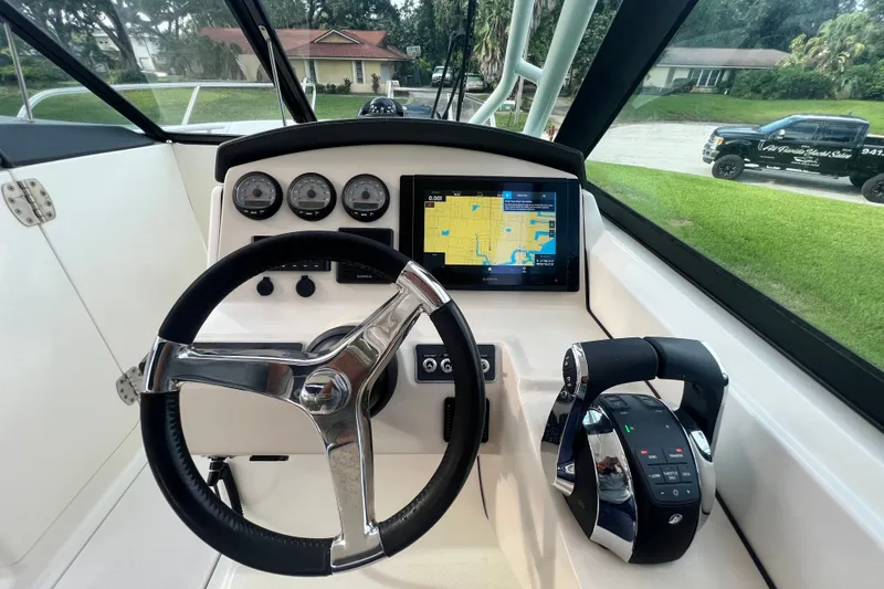 Slide: The Image of 2015 Boston Whaler 270 Vantage helm with steering wheel, gauges, and navigation display. - 77