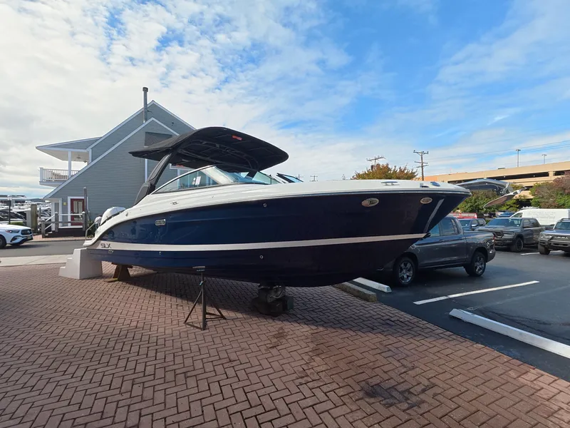 Slide: The Image of A 2027 Sea Ray SLX 280 Outboard is on a paved parking area. The boat features a sleek design. - 1