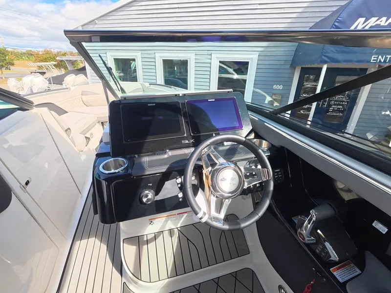Slide: The Image of The image shows the cockpit of a 2027 Sea Ray SLX 280 Outboard with modern instruments and a sleek steering wheel. - 19
