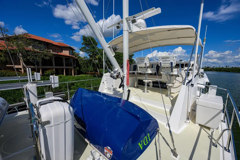 Slide: The Image of 2013 Krogen 44' AE Widebody yacht deck with seating, blue cover, and scenic waterfront view. - 31