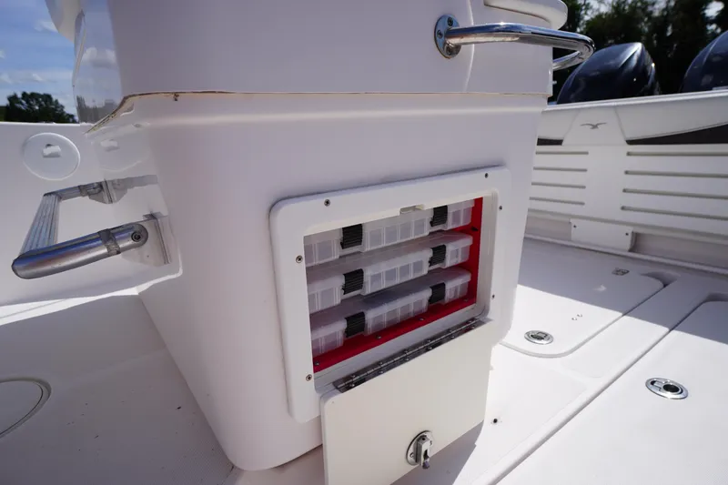 Slide: The Image of 2016 Pro-Line 29 Grand Sport boat storage compartment with tackle boxes on deck. - 36