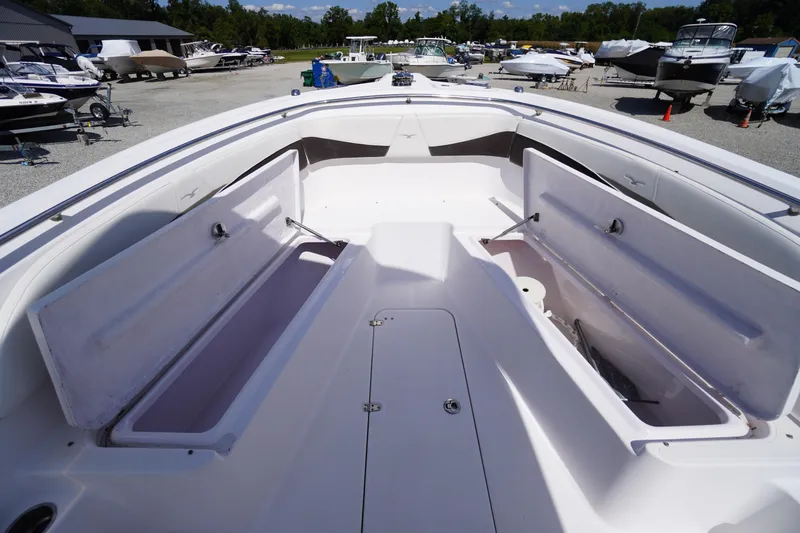 Slide: The Image of 2016 Pro-Line 29 Grand Sport boat with open storage compartments in a marina. - 10