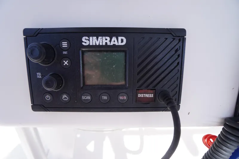 Slide: The Image of Simrad marine radio on 2016 Pro-Line 29 Grand Sport boat dashboard. - 32