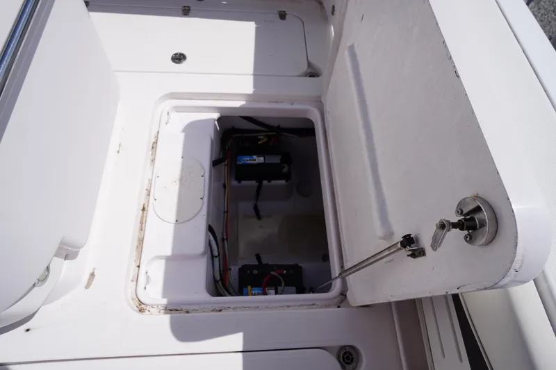 Slide: The Image of Open storage compartment on a 2016 Pro-Line 29 Grand Sport boat, revealing marine batteries. - 52