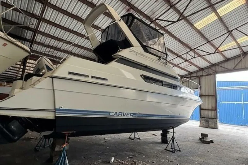 Slide: The Image of 1991 Carver 3067 Santego yacht in storage, elevated on stands inside a metal warehouse. - 7