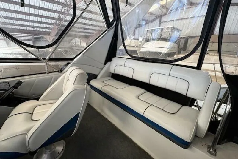 Slide: The Image of Interior of a 1991 Carver 3067 Santego boat with white seating and clear windows. - 12