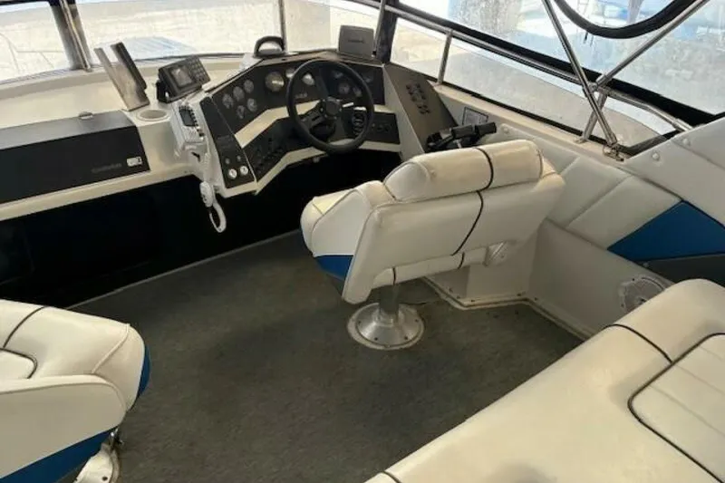 Slide: The Image of Interior of a 1991 Carver 3067 Santego boat with white seating and control panel. - 9