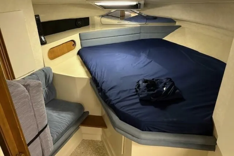Slide: The Image of Cozy cabin interior of 1991 Carver 3067 Santego with blue bedding and seating. - 21