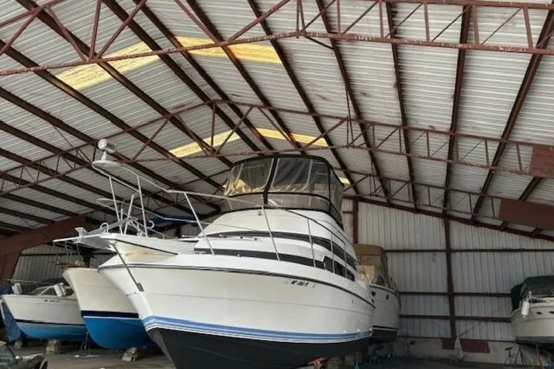 Slide: The Image of 1991 Carver 3067 Santego yacht stored in a spacious metal warehouse. - 4