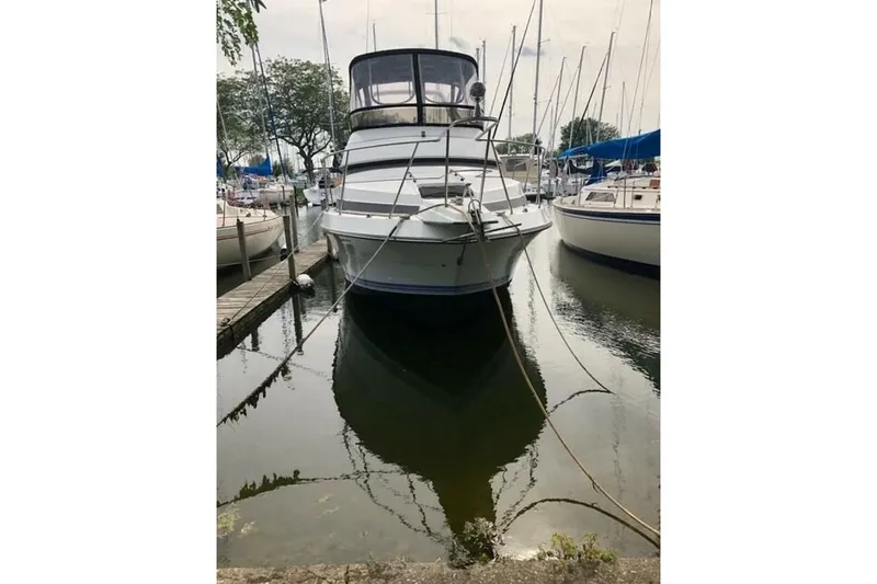 Slide: The Image of 1991 Carver 3067 Santego yacht docked in a marina, surrounded by sailboats. - 2