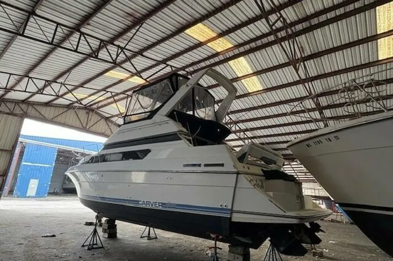 Slide: The Image of 1991 Carver 3067 Santego yacht stored indoors on stands in a spacious warehouse. - 6