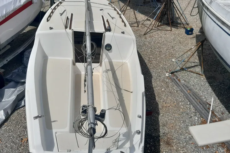 Slide: The Image of 1979 Clark San Juan sailboat on gravel, showing deck and mast details. - 8