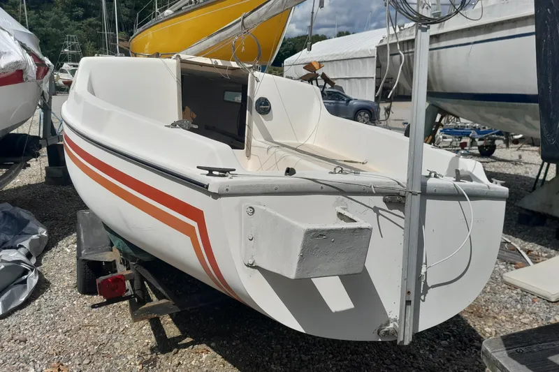 Slide: The Image of 1979 Clark San Juan sailboat with red stripes on a trailer in a boatyard. - 2