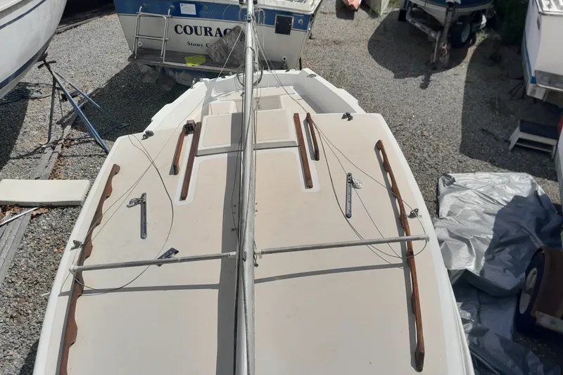 Slide: The Image of 1979 Clark San Juan sailboat deck with rigging, docked among other boats. - 6