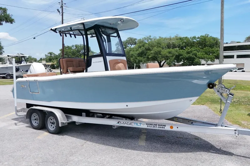 The Image of 2027 Sea Hunt Ultra 235 SE boat on trailer, parked outdoors on a sunny day. - 1