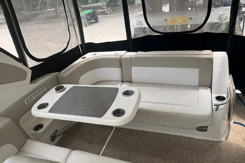 Slide: The Image of 2015 Chaparral 310 Signature boat interior with seating and table setup. - 11