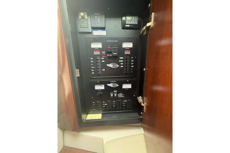 Slide: The Image of Electrical panel inside 2015 Chaparral 310 Signature boat, featuring circuit breakers and controls. - 5