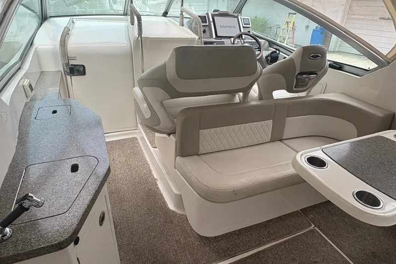 Slide: The Image of 2015 Chaparral 310 Signature boat interior with seating, helm, and kitchenette area. - 14