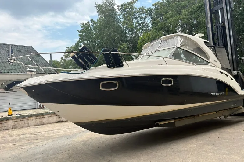 Slide: The Image of 2015 Chaparral 310 Signature boat on dry dock, surrounded by trees and buildings. - 4