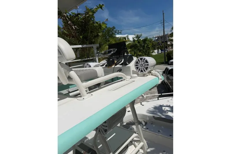 Slide: The Image of 2023 Caymas 281 HB boat with modern seating and steering, outdoors in a sunny setting. - 2