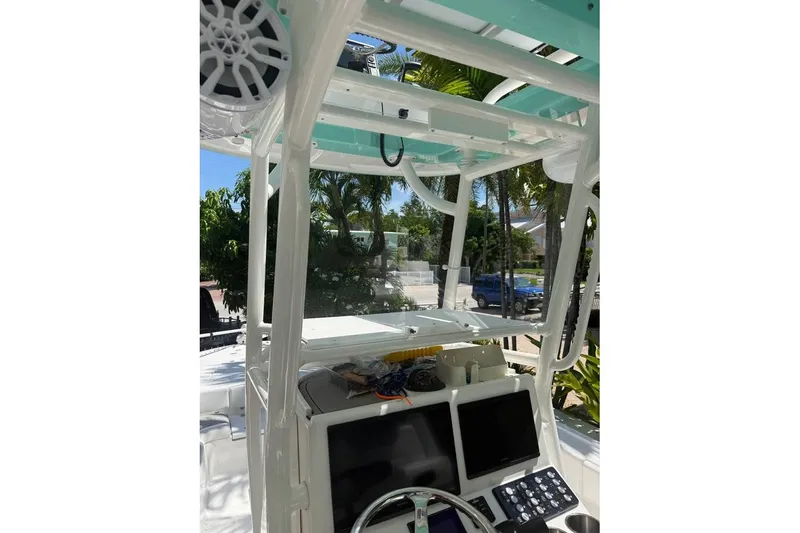 Slide: The Image of 2023 Caymas 281 HB boat console with electronics and speakers, surrounded by tropical greenery. - 4