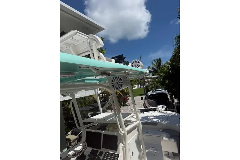 Slide: The Image of 2023 Caymas 281 HB boat with modern console and speakers, parked outdoors under blue sky. - 3