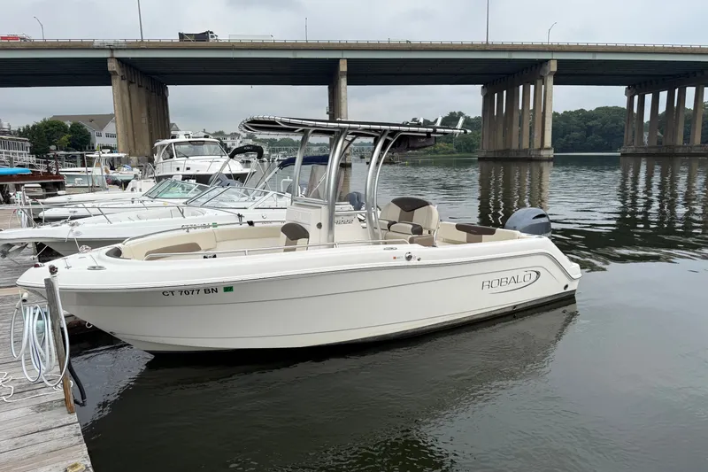 Slide: The Image of 2019 Robalo R222 Explorer boat docked by a bridge on a calm river. - 1
