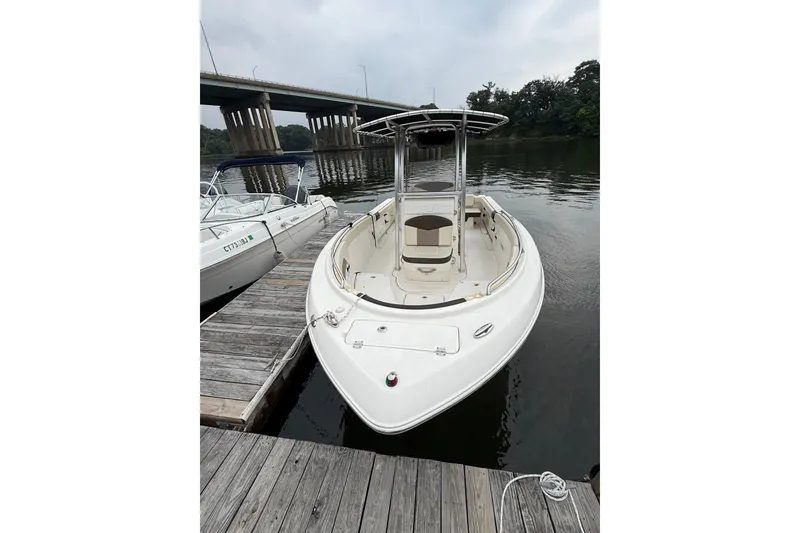 Slide: The Image of 2019 Robalo R222 Explorer boat docked on calm water near a bridge. - 3