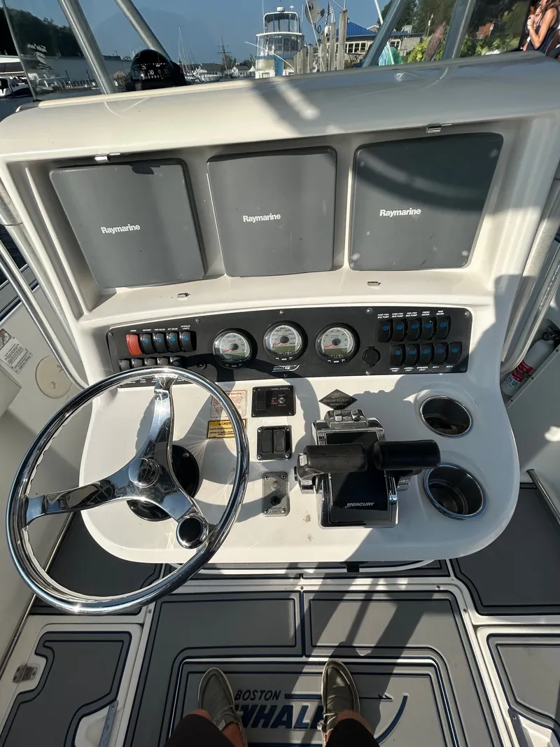 Slide: The Image of Helm of a Boston Whaler 270 Outrage with multiple screens and instruments. - 10