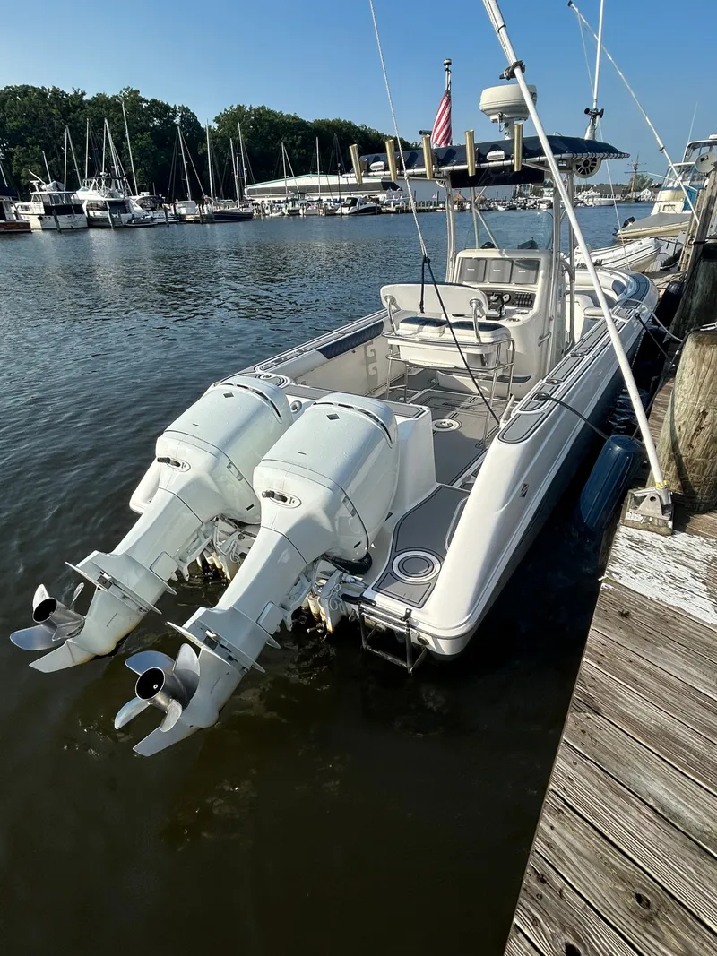 Slide: The Image of A 2004 Boston Whaler 270 Outrage docked. It features twin outboard engines. - 3