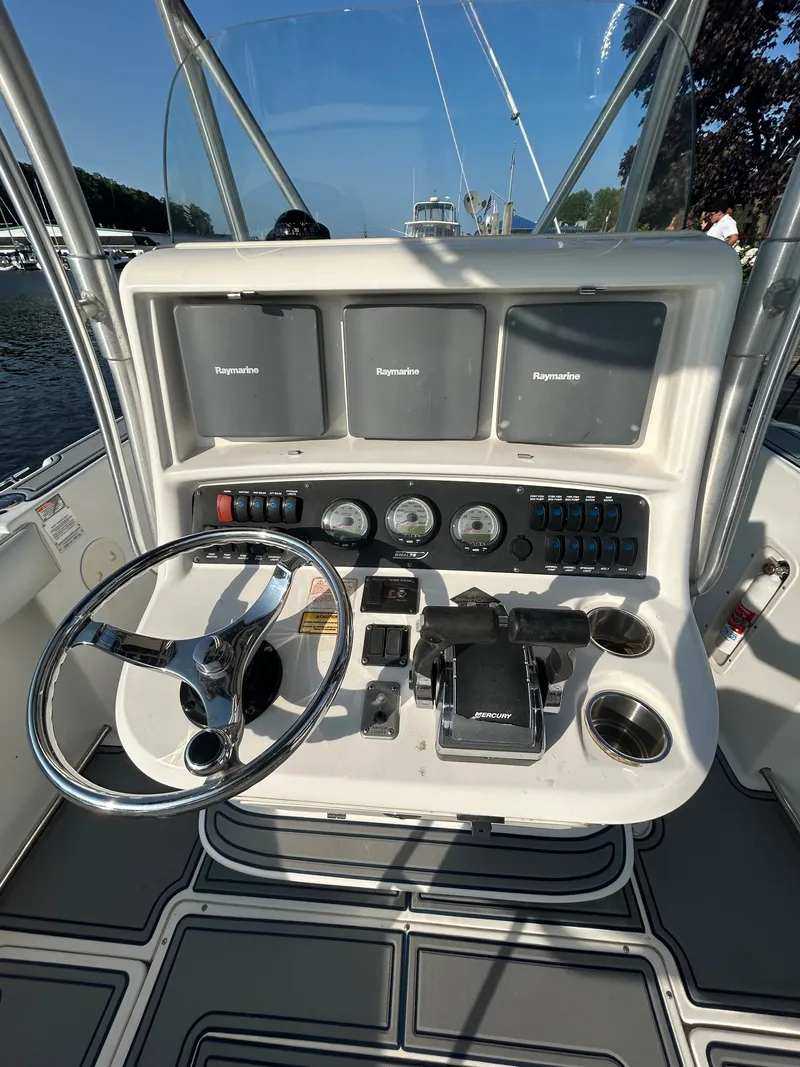 Slide: The Image of The cockpit of a 2004 Boston Whaler 270 Outrage with steering wheel, gauges, and Raymarine displays. - 6